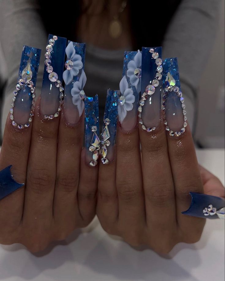 Elegant Coffin-Shaped Nail Design with Blue Hues, Glitter, and Floral Patterns.