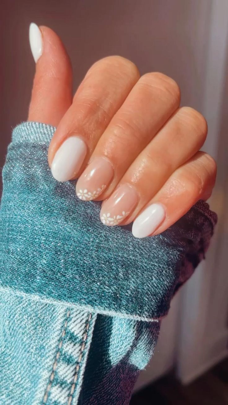 Elegant Glossy White and Beige Nail Design with Delicate Flower Accents for a Fresh, Modern Look.