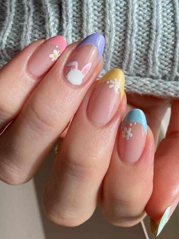 Playful Spring Nail Design: Pastel Shades and Floral Motifs with Whimsical Bunny Illustrations.