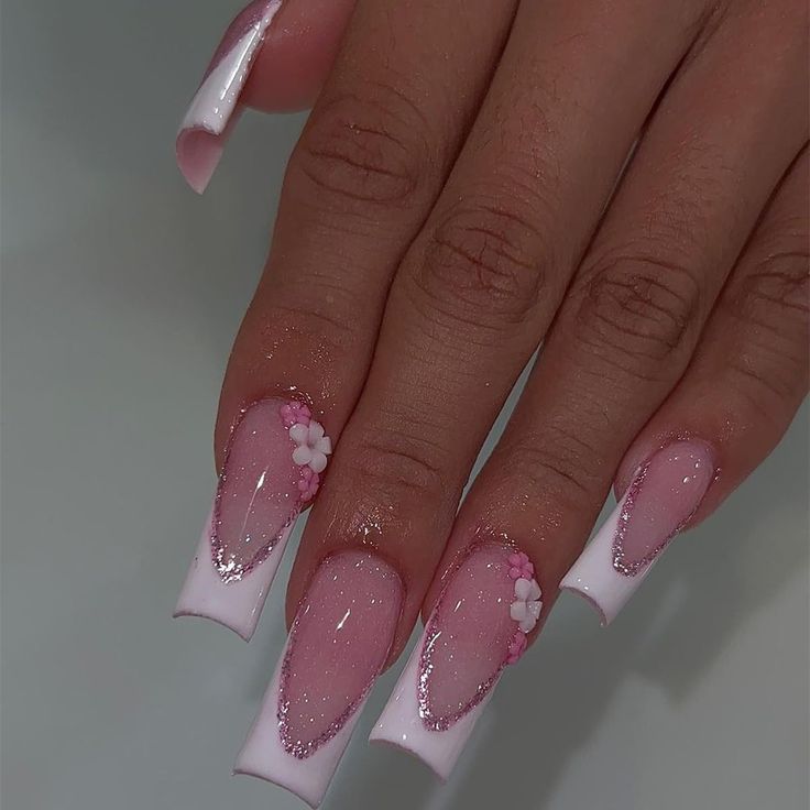 Sophisticated French Tip Nails: Soft Pink and White with Floral Accents and Sparkling Glitter.