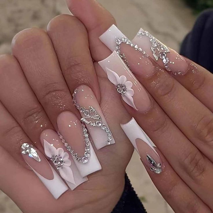 Glamorous Soft Pink and White Nail Design with Floral Accents and Rhinestones.