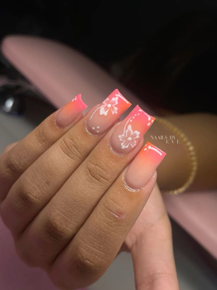 Vibrant Ombre Pink Nail Design with Floral Patterns and Dot Accents for a Playful Summer Look.