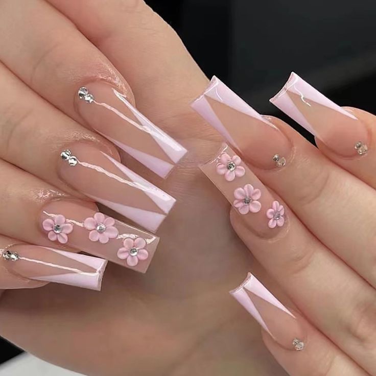 Elegant Pink and Clear Nail Design with Floral Embellishments and Sparkling Accents.