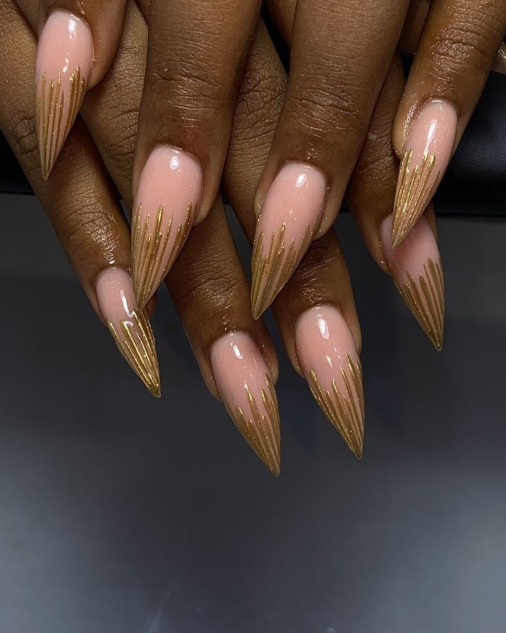 Chic Stiletto Nails: Sophisticated Nude Base with Dramatic Golden Accents.