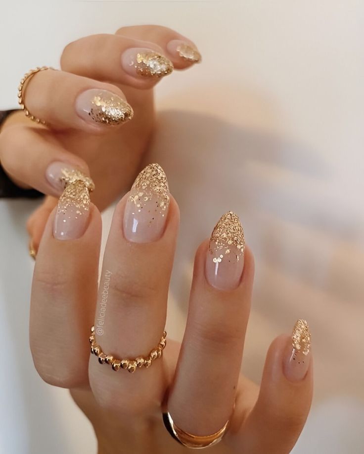 Sophisticated Nude Nails with Gold Glitter Tips and Elegant Accents.