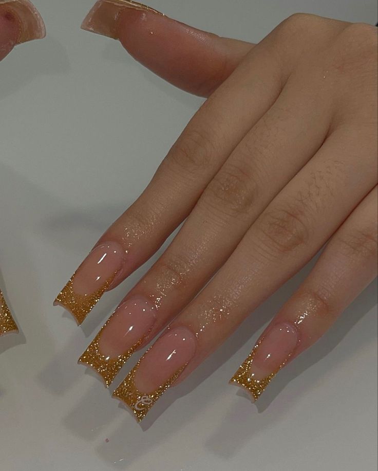 Chic Glittery Nail Design with Elongated Tips and Elegant Gold Detailing