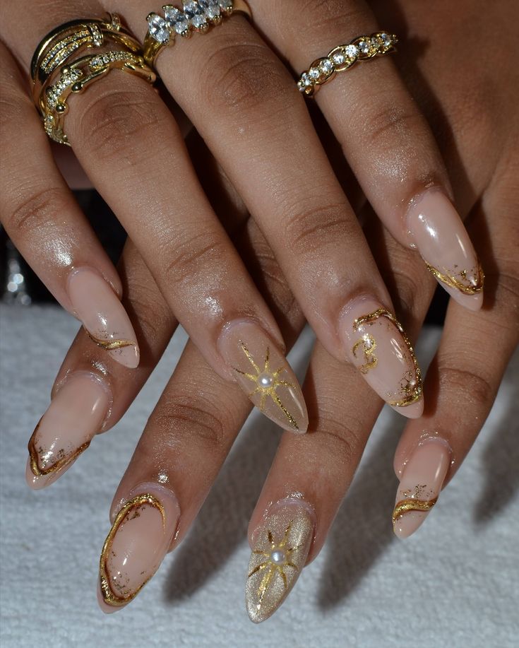 Sophisticated Nude Nail Design with Intricate Gold Detailing and Pearl Accents.