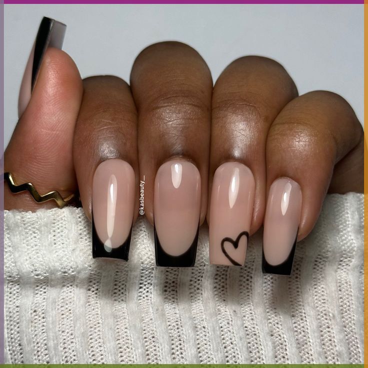 Chic Nude and Black Tip Nail Design with Playful Heart Accent.