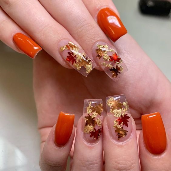 Elegant Autumn-Inspired Nail Design with Vibrant Orange and Metallic Leaf Accents