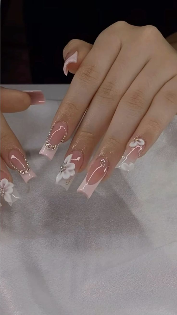 Chic Pink and White Floral Nail Design with Bead Accents for Special Occasions.