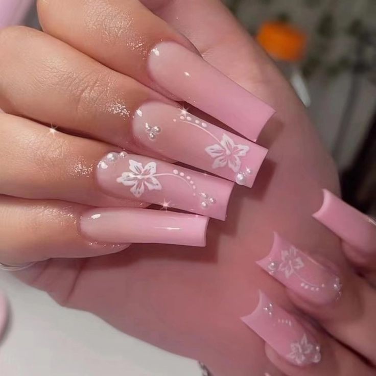 Glamorous Ombre Nails with Elegant Pink Gradient and Floral Designs.