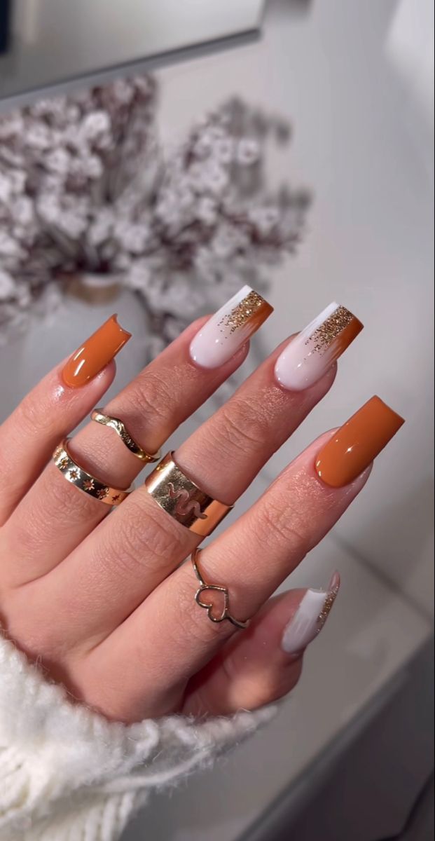 Elegant Orange and White Gradient Nail Design with Gold Accents and Rings