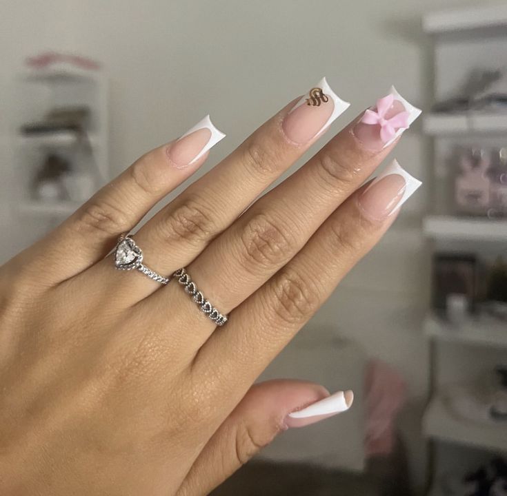 Chic French Manicure: Soft Pink Base with White Tips, Bow Detail, and Gold Accents.