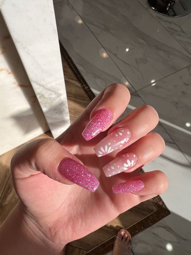 Playful and Chic: Glittery Pink Nails with Elegant Floral Accents.