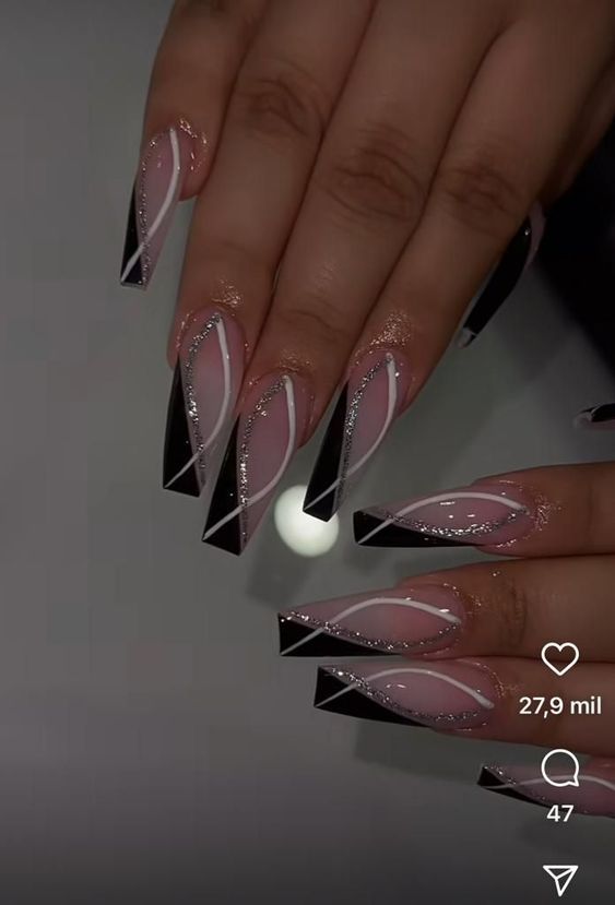 Elegant Stiletto Nail Design: Nude and Black with White Lines and Glitter Accents