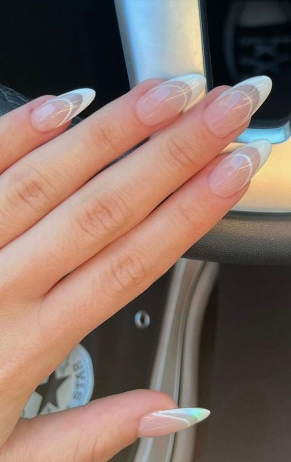 Sophisticated Nail Design: Soft Nude Shades with Striking White Tips and Elegant Swirls