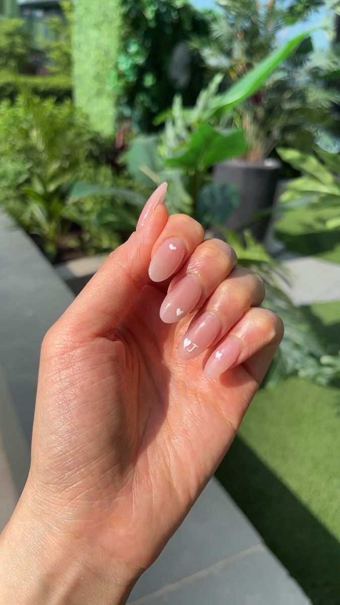 Elegant Almond-Shaped Nude Nails with White Heart Accents and Subtle Gradient for a Romantic Look.