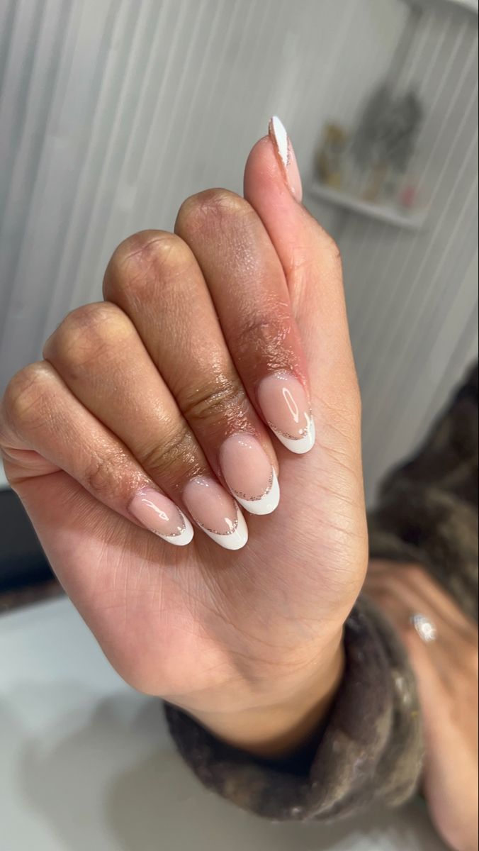 Chic French Tip Nail Design: Sophisticated Nude Base with Delicate White Tips and Subtle Shimmer.