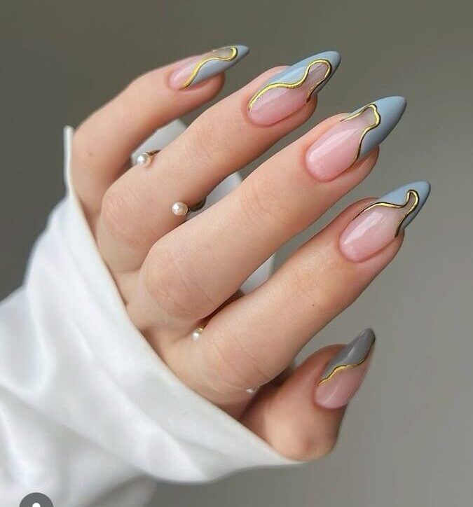 Sophisticated Almond-Shaped Nail Design in Soft Pink and Cool Gray with Elegant Gold Accents.