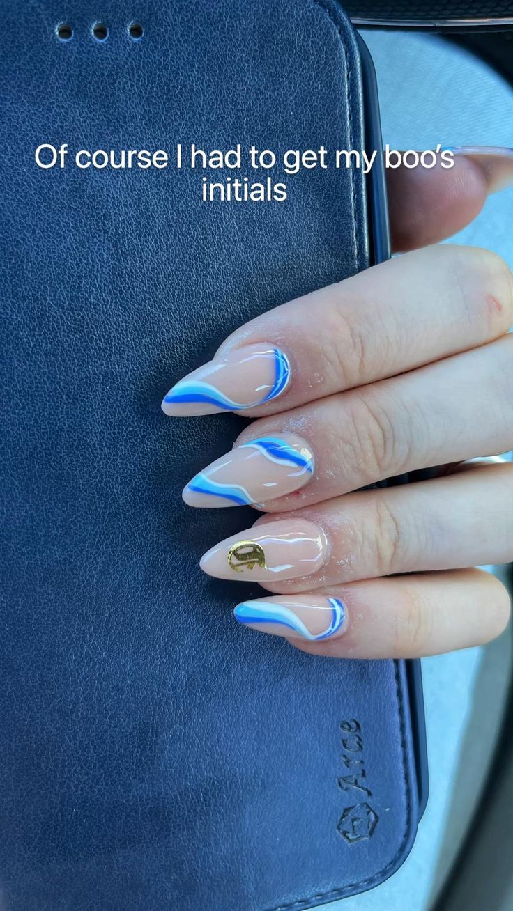 Chic Almond-Shaped Nails: Elegant Nude and Blue Design with Gold Accents and Personalized Touch.