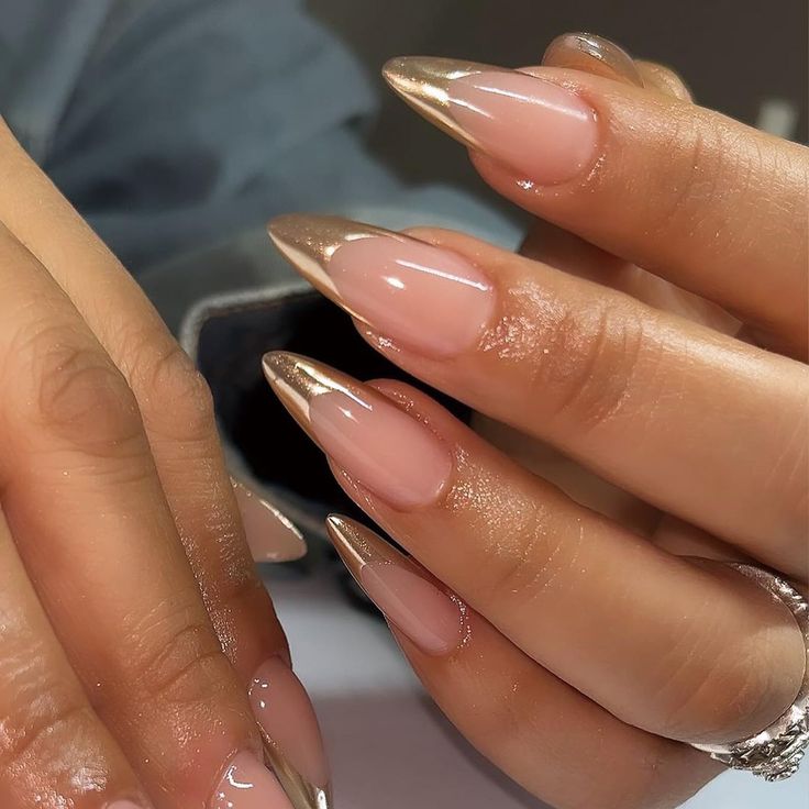 Chic Almond-Shaped Nails with Soft Nude Base and Metallic Gold Tips: A Modern Twist on the Classic French Manicure.