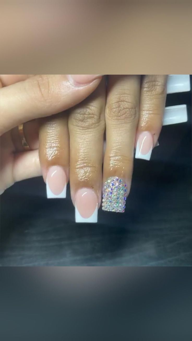 Elegant Glam Nail Design: Nude Gradient with White Tips & Rhinestone Accent.