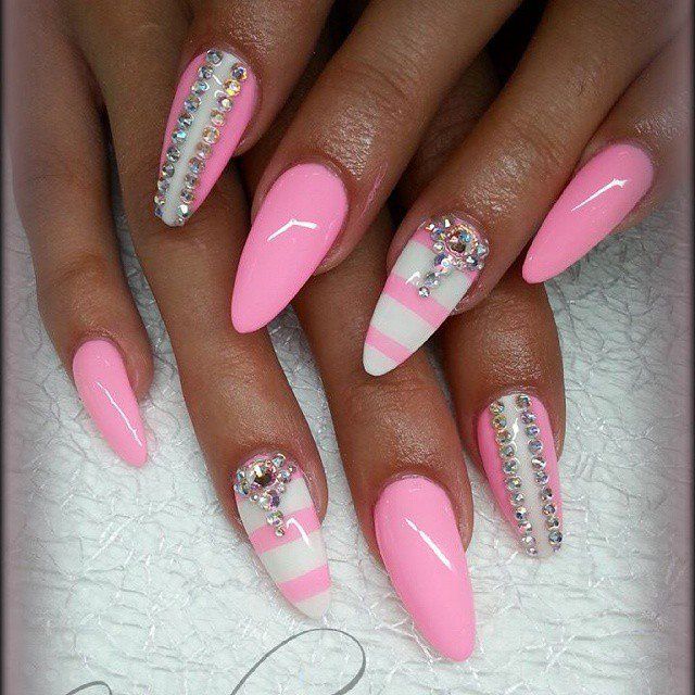 Glamorous Pink Almond Nails with Sparkling Rhinestones and Elegant White Stripes.