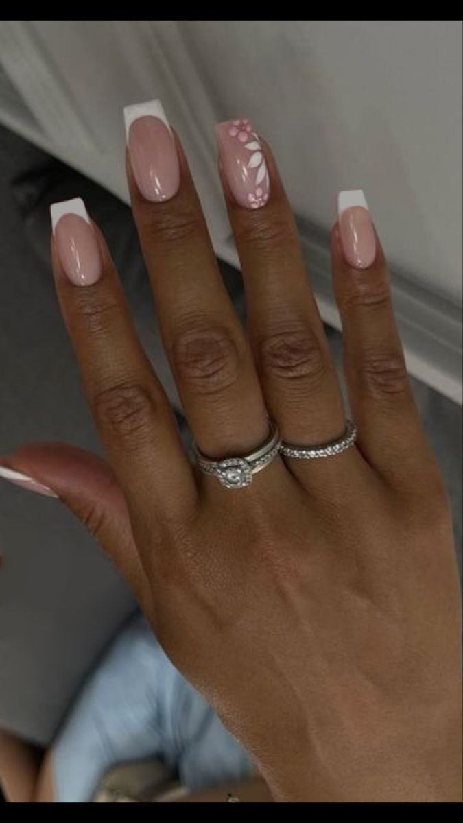 Chic Pink French Tip Nails with Floral Accent and Sparkling Rings for Any Occasion.