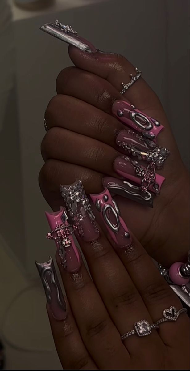 Glamorous Pink and Silver Elongated Acrylic Nail Art with Intricate Embellishments.