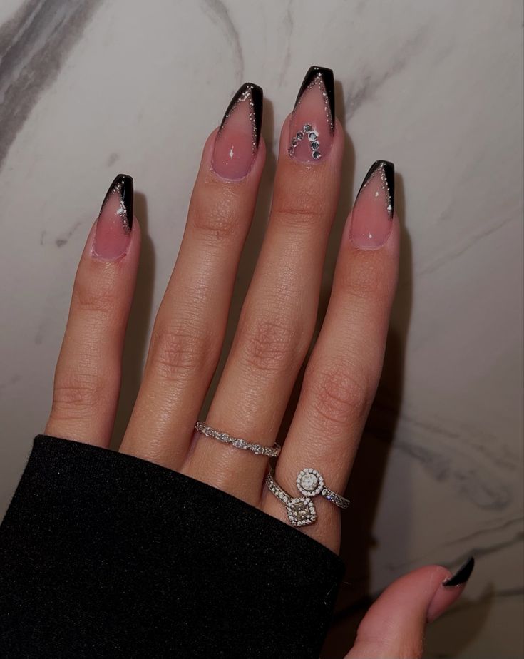 Chic Black-Tipped Nude Nails with Glamorous Silver Embellishments.