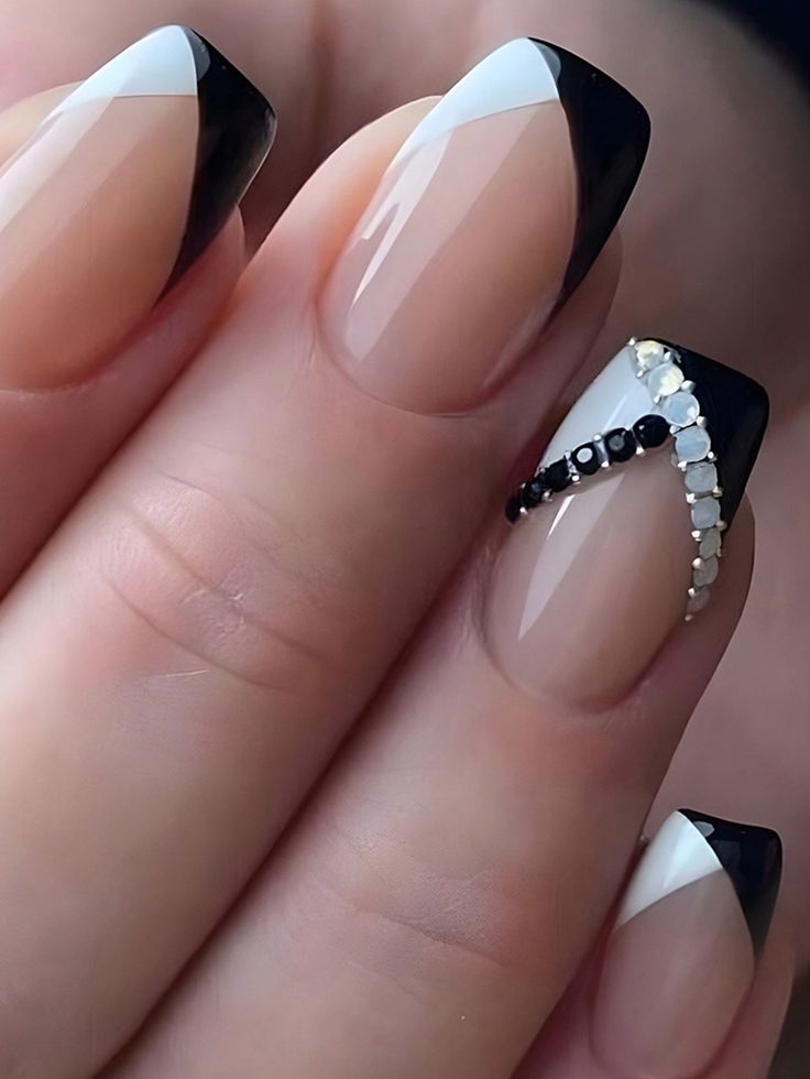 Chic French Manicure Redefined: Sophisticated Nude, Black, and White with Gem Accents.