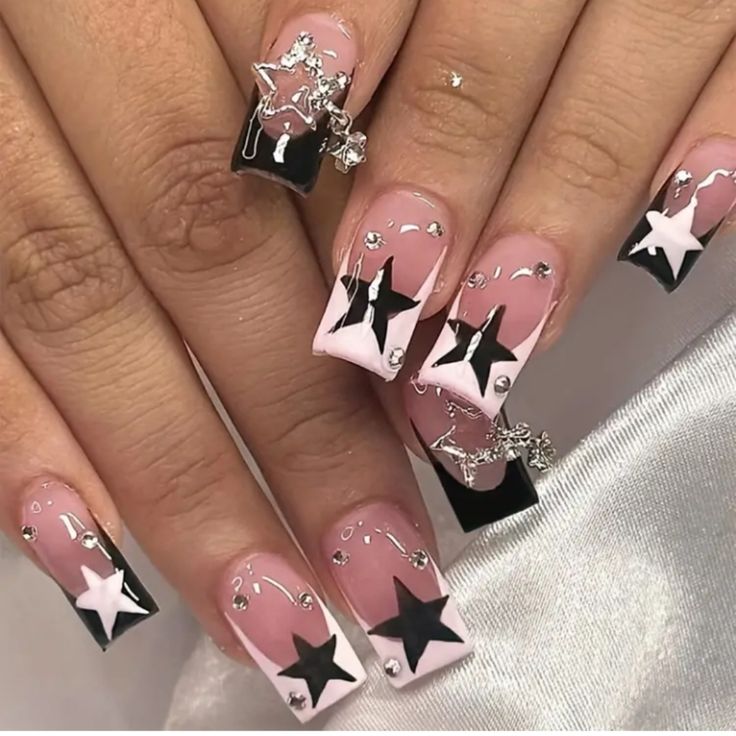 Chic Nail Design: Pastel Pink and Bold Black with Star Shapes and Silver Accents