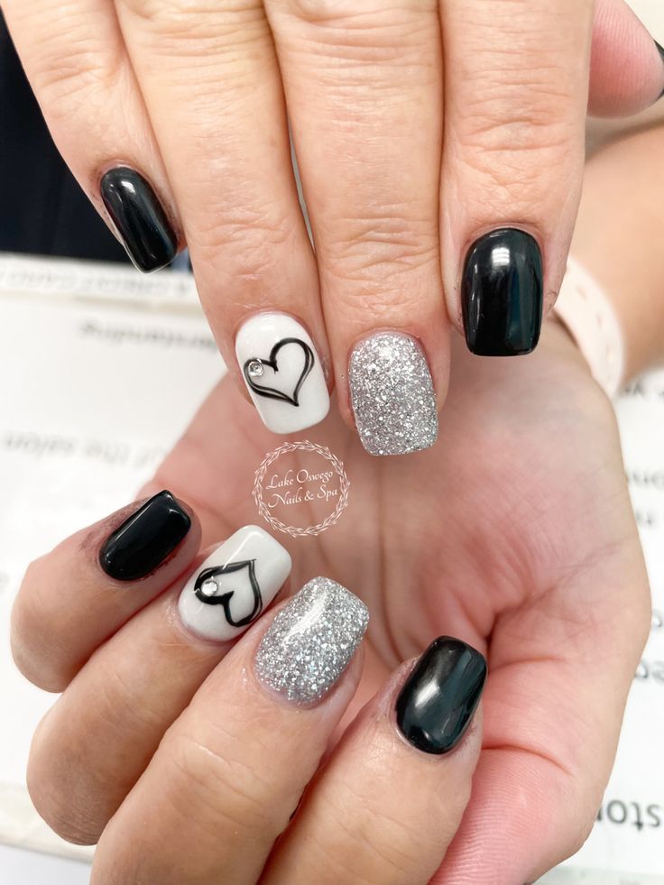 Stylish Black and White Elegant Nail Design with Heart Patterns and Sparkly Silver Accents