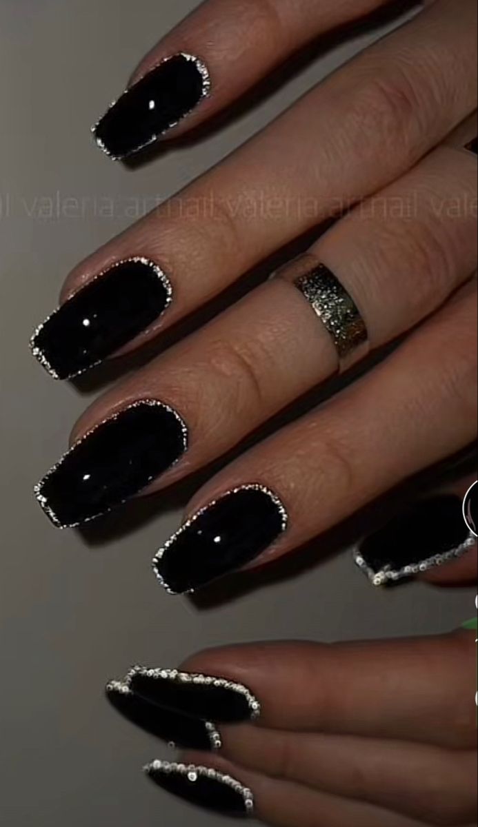 Sophisticated Black Nail Design with Silver Edges and Rhinestones.