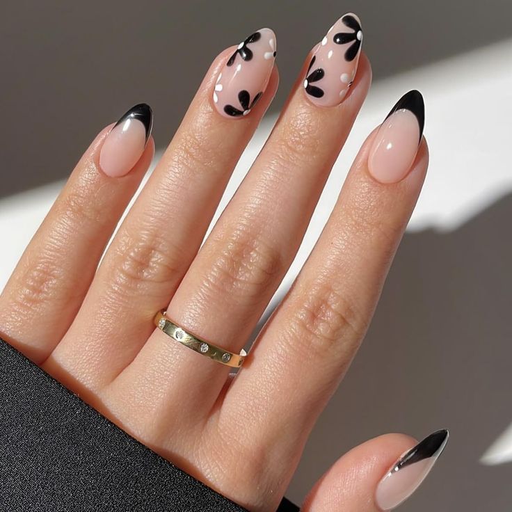 Chic Soft Pink Nail Design with Bold Black French Tips and Delicate Floral Accents.