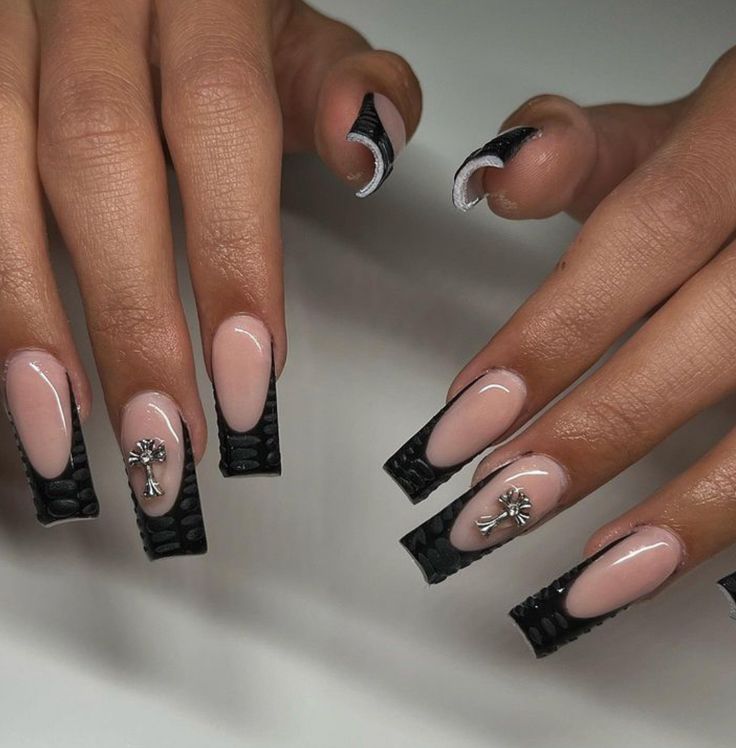 Chic Nude and Bold Black Nail Design with Textured Tips and Silver Accents.