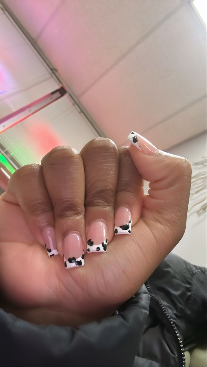 Chic Cow-Patterned Nail Design: Soft Pink Base with Playful Black Spots.