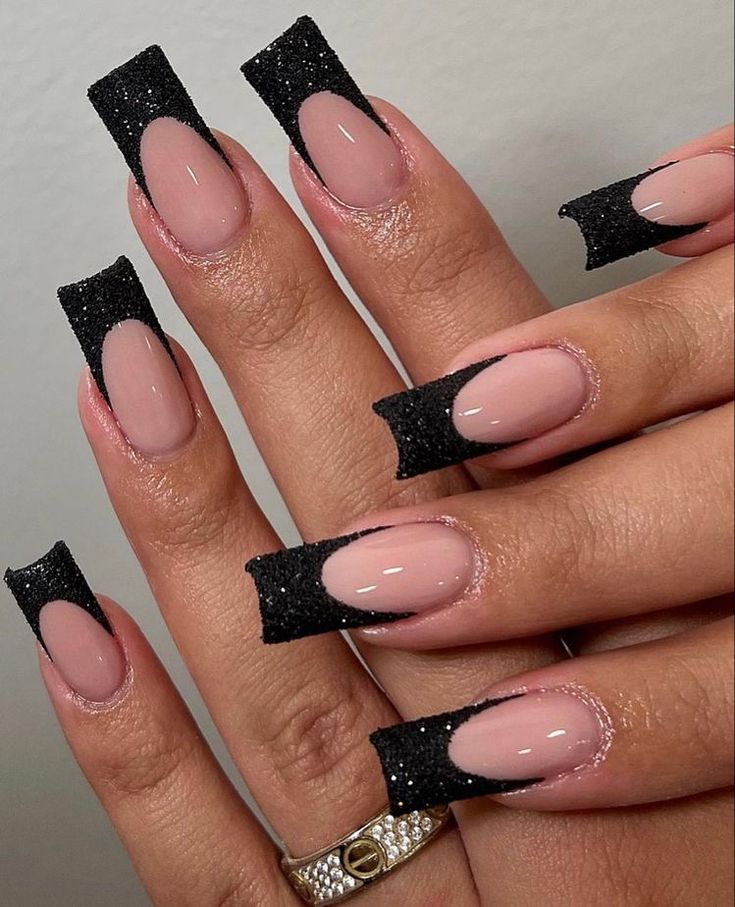 Elegant Nail Design with Nude Polish and Black Glitter Tips for a Bold Glamorous Look.