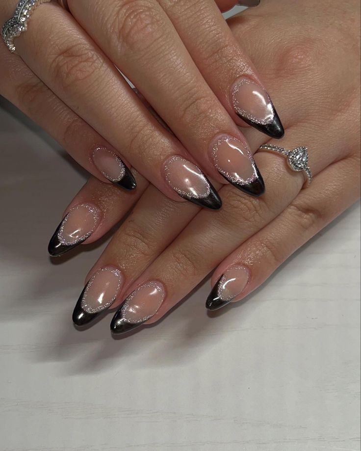 Chic Almond-Shaped Nails: Nude Base, Bold Black Tips, and Sparkling Cuticle Accents.