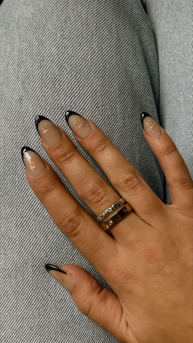 Chic Elegant Nude Nail Design with Bold Black Tips and Whimsical Star Accents.