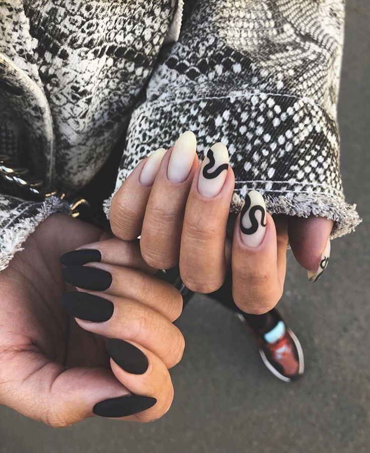 Stylish Chic Nail Design: Matte Black and Ombre with Bold Abstract Patterns.