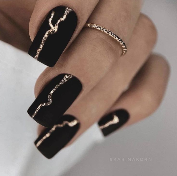 Chic Black Matte Nails with Intricate Gold Accents.