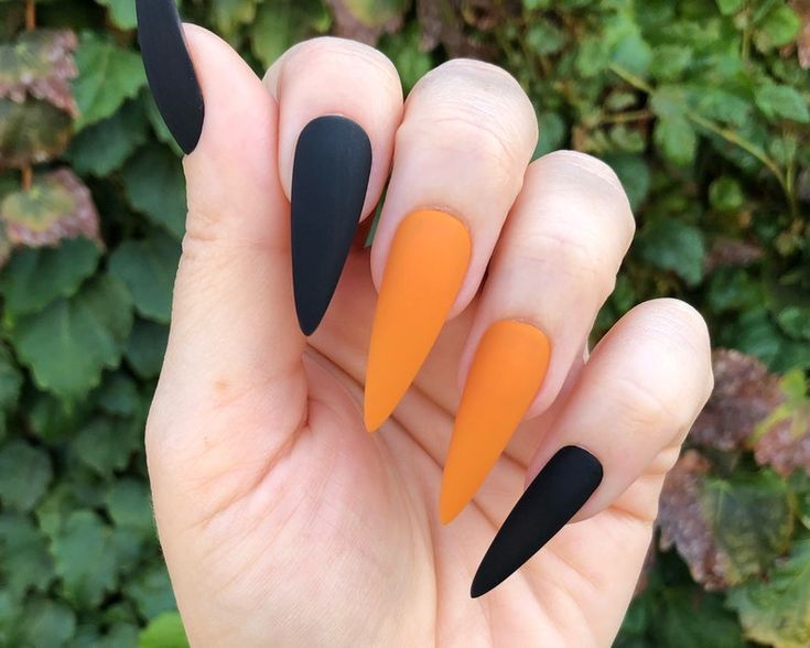 Bold Matte Black and Vibrant Orange Stiletto Nail Design for Every Occasion.