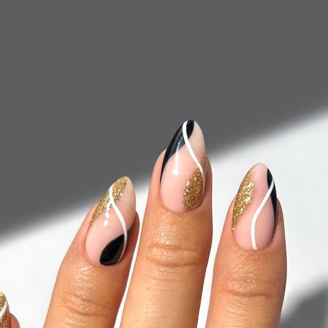 Elegant Chic Nail Design: Nude and Black with Gold Glitter and Striking White Details.