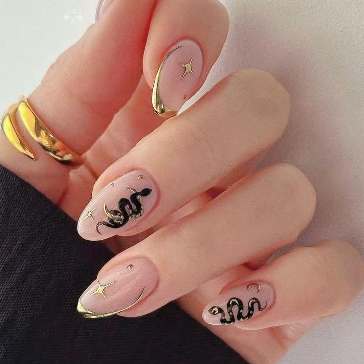 Sophisticated Soft Pink Nail Design with Gold Tips and Edgy Black Snake Illustrations.