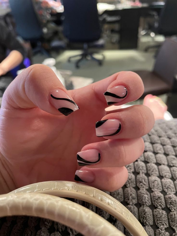 Chic Nail Design: Modern French Tips with Soft Pink and Bold Black Accents.