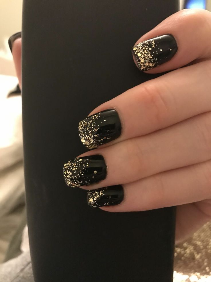 Stunning Elegant Nail Design: Deep Black Polish with Glamorous Gold Glitter Gradient.