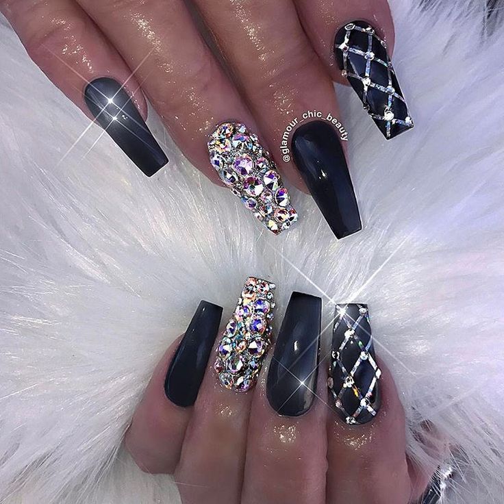 Elegant Matte Black and Shimmering Nail Design with Rhinestones and Patterns for Glamorous Occasions.