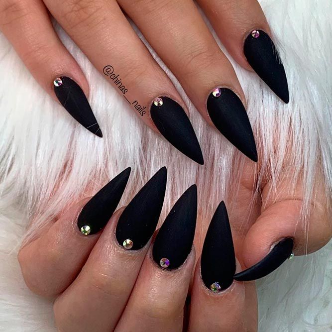 Bold Matte Black Stiletto Nails Embellished with Sparkling Gemstones.