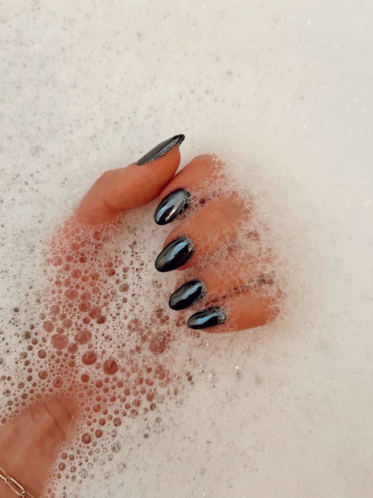 Elegant Glossy Black Nails Enhance Relaxing Foamy Scene with Chic Sophistication.